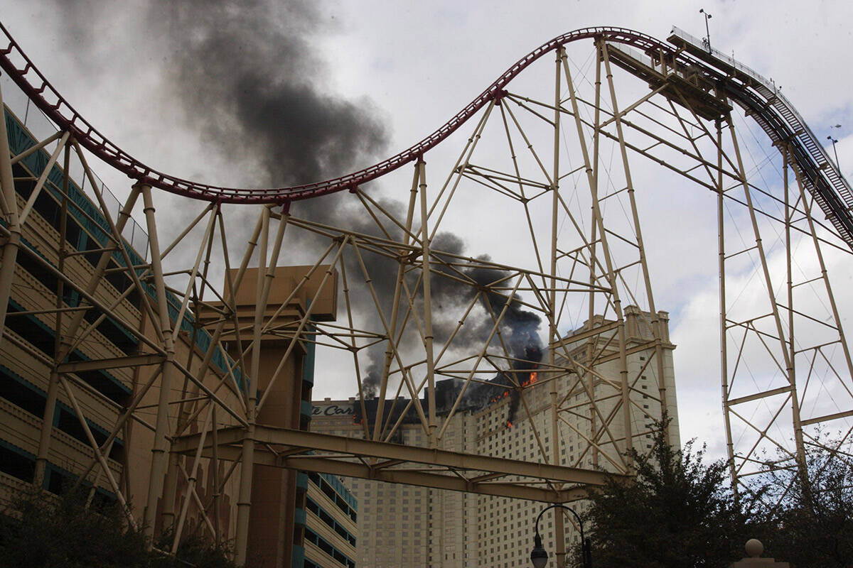 Flames burning along the upper exterior of the Monte Carlo hotel-casino are framed by the Manha ...