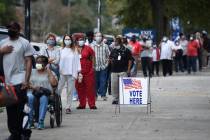 In this Oct. 12, 2020, file photo, people wait in line for early voting at the Bell Auditorium ...