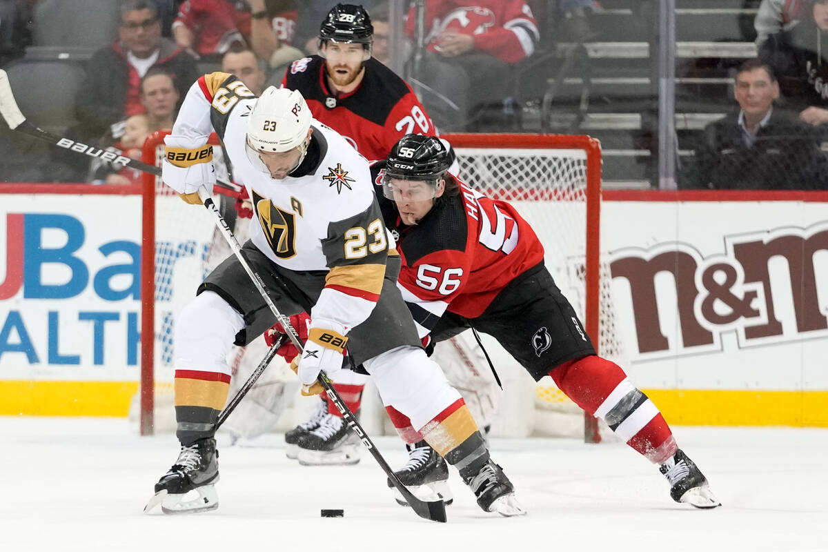 Vegas Golden Knights defenseman Alec Martinez (23) fights for the puck against New Jersey Devil ...