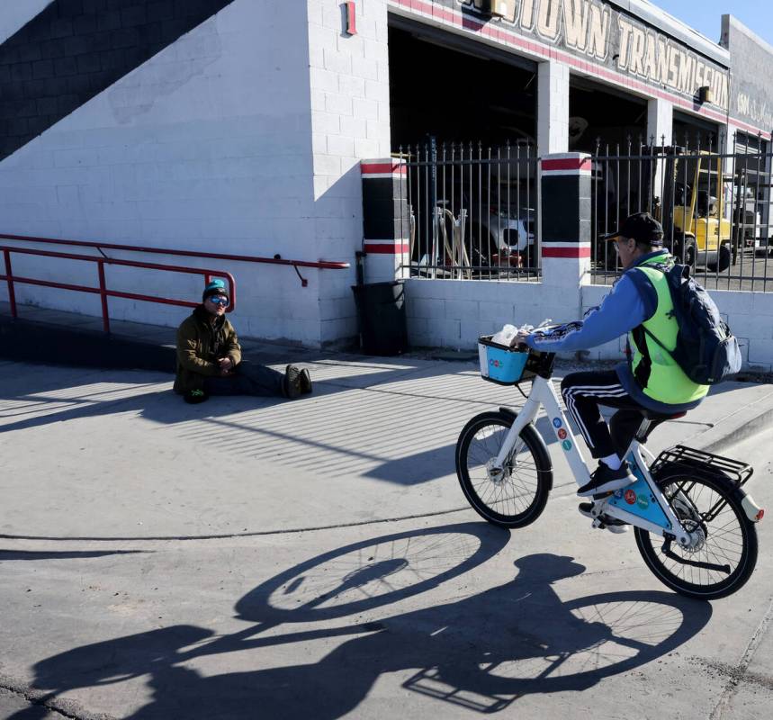 Richard Birmingham, right, rides up to offer food and resource information to Gabriel Capone du ...