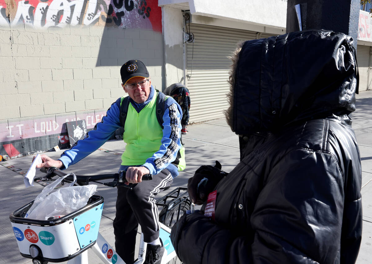 Richard Birmingham, left, offers food and resource information to a person who gave their name ...