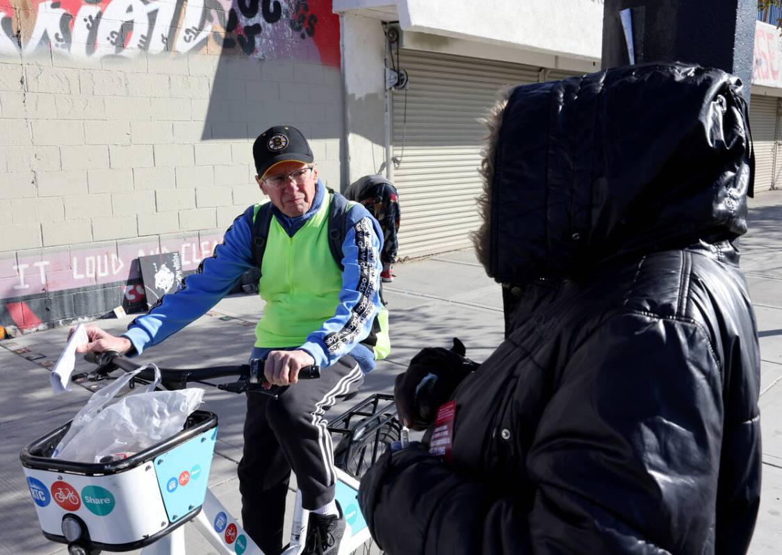 Richard Birmingham, left, offers food and resource information to a person who gave their name ...