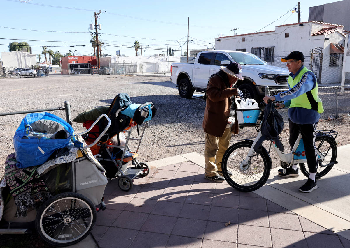 Richard Birmingham, right, offers food and resource information to Edna De La Fuente during his ...