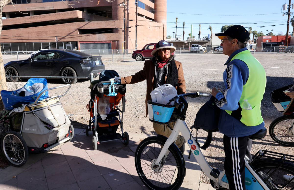 Richard Birmingham, right, offers food and resource information to Edna De La Fuente during his ...