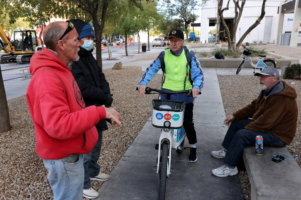 Richard Birmingham, center, offers food and resource information during his daily bicycle outre ...