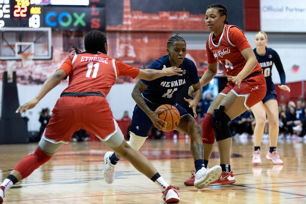 Nevada Wolf Pack guard Victoria Davis (11) drives toward the hoop between UNLV Lady Rebels guar ...