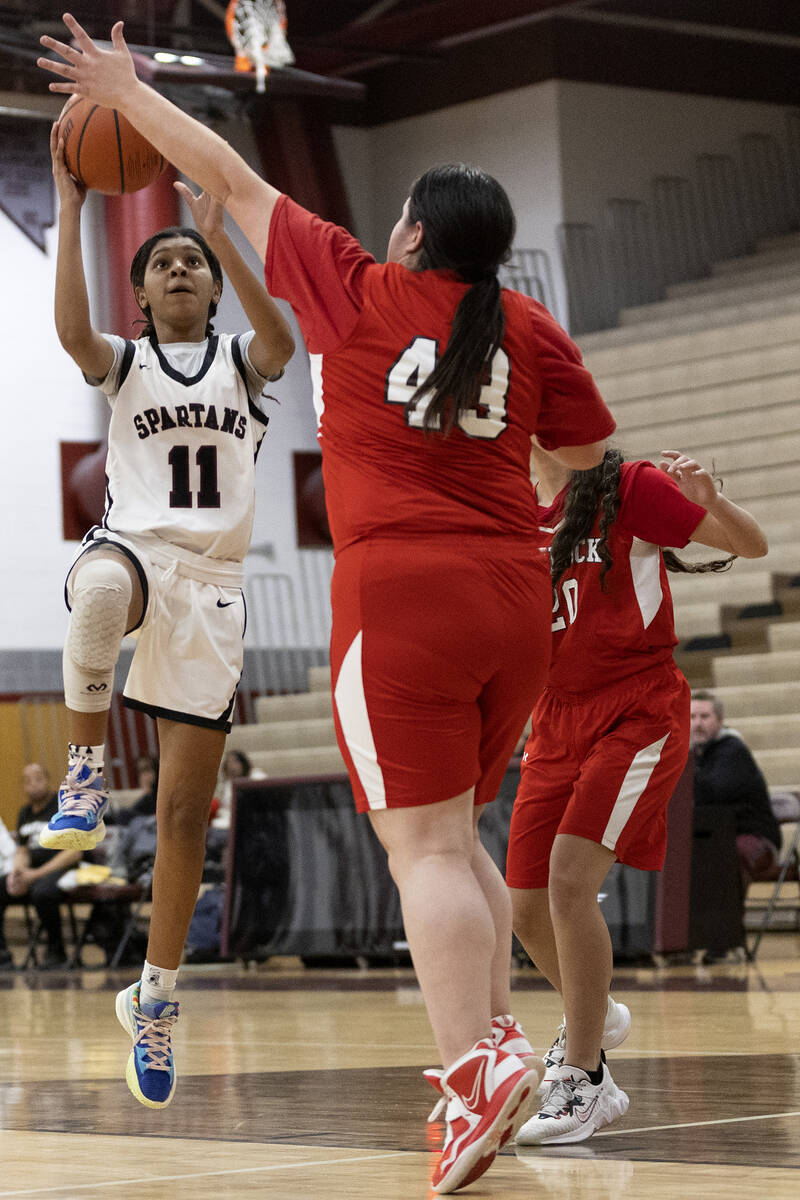 Cimarron-Memorial’s Heaven Hill (11) shoots against Doral’s Amanda Orasi (43) dur ...