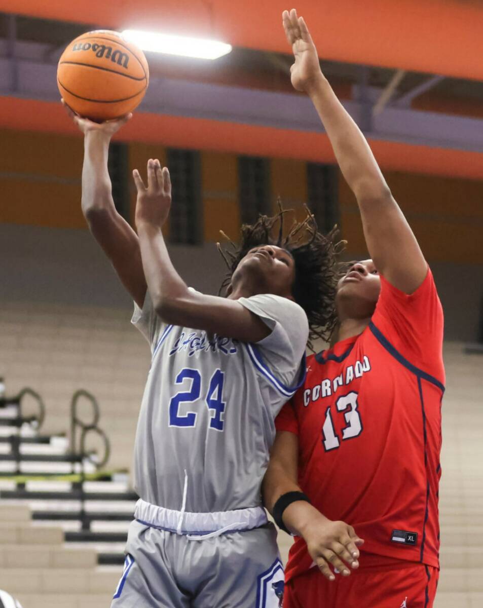 Coronado's Tee Bartlett (13) defends as Desert Pines' Damonte Duhart (24) lays up a shot during ...