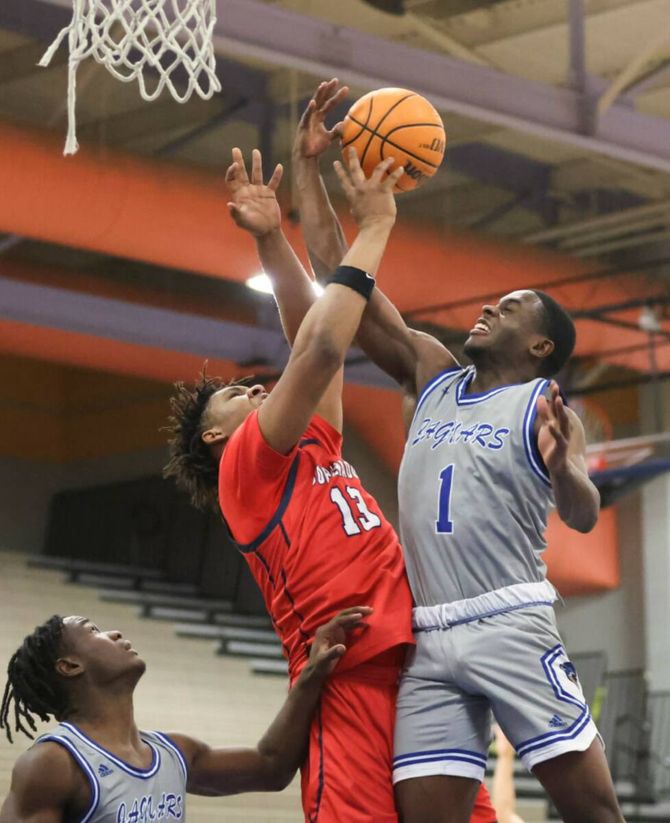 Coronado's Tee Bartlett (13) and Desert Pines' Kameron Ricks (1) fight for a rebound during the ...