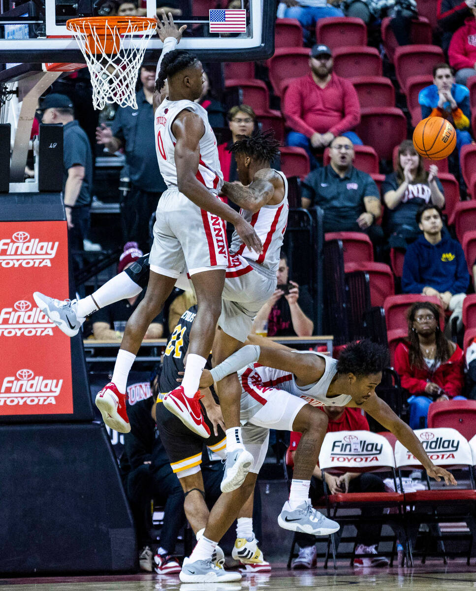 UNLV forward Victor Iwuakor (0) and teammates defend the basket from Wyoming guard Kenny Foster ...