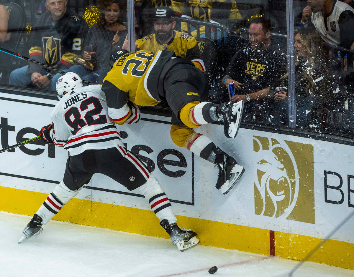 Chicago Blackhawks defenseman Caleb Jones (82) upends Golden Knights left wing William Carrier ...