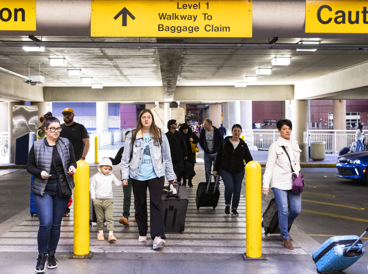 Arriving passengers walk to retrieve their vehicles from the level 2 of Terminal 1 parking lot ...