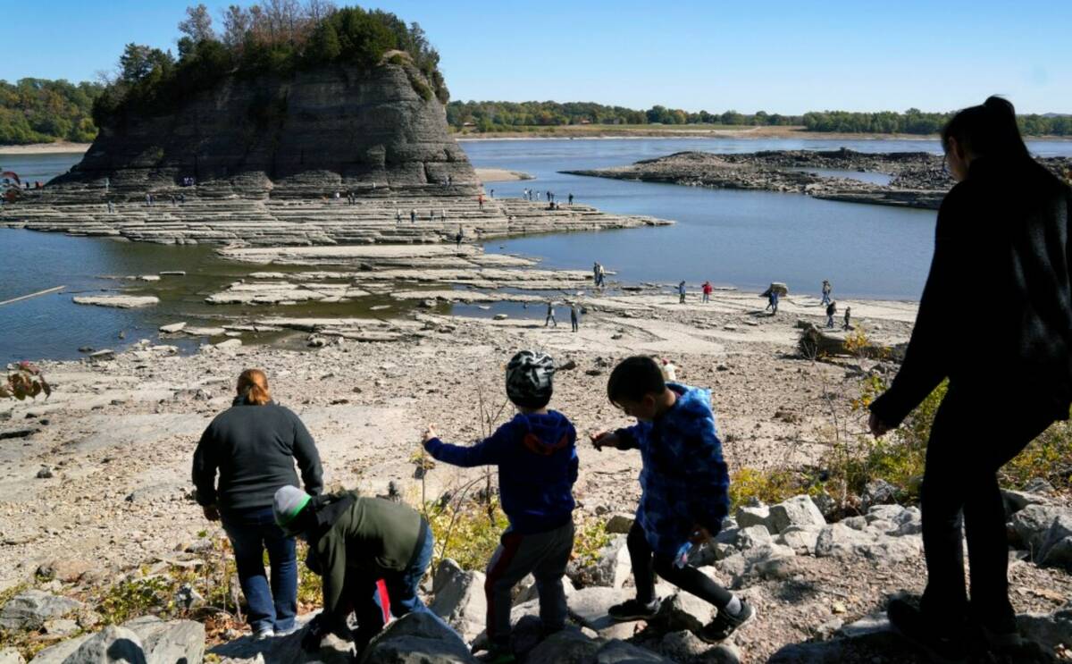 People walk toward Tower Rock to check out the attraction normally surrounded by the Mississipp ...