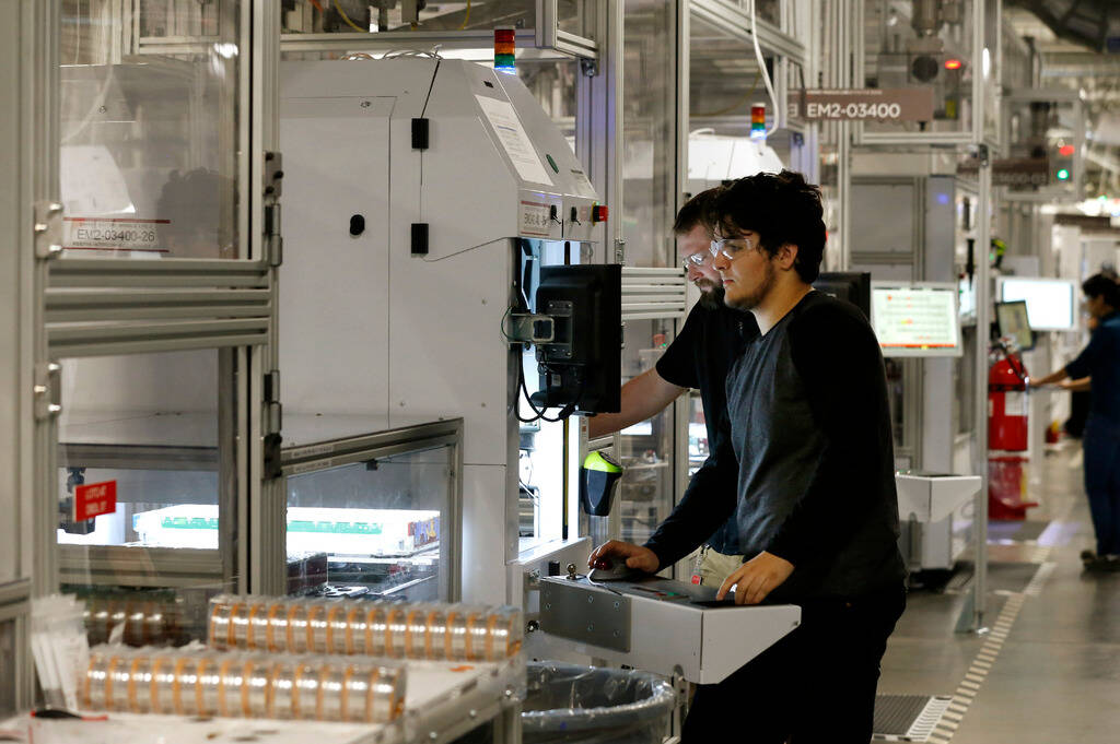 Jon Rabago and Nick Frank work on the module line for power wall and power packs at the Tesla G ...