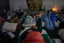 Lorenzo Gonzales, center, and other retreat participants reach their hands to the sky during a ...