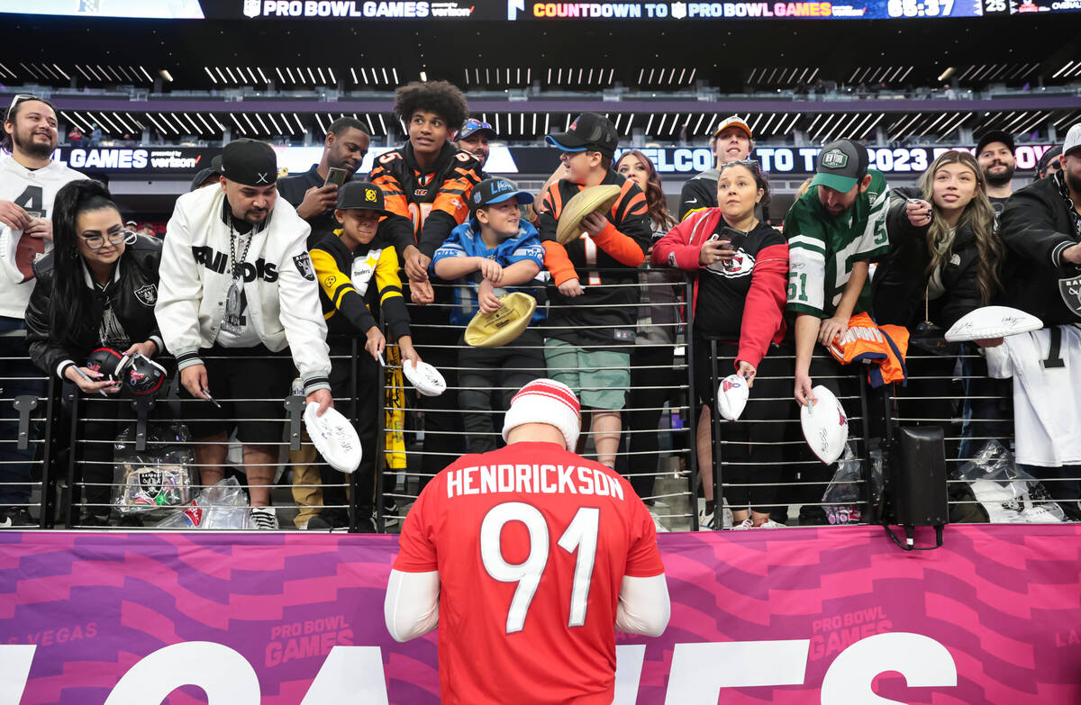 Cincinnati Bengals defensive end Trey Hendrickson (91) signs items for fans before the NFL Pro ...