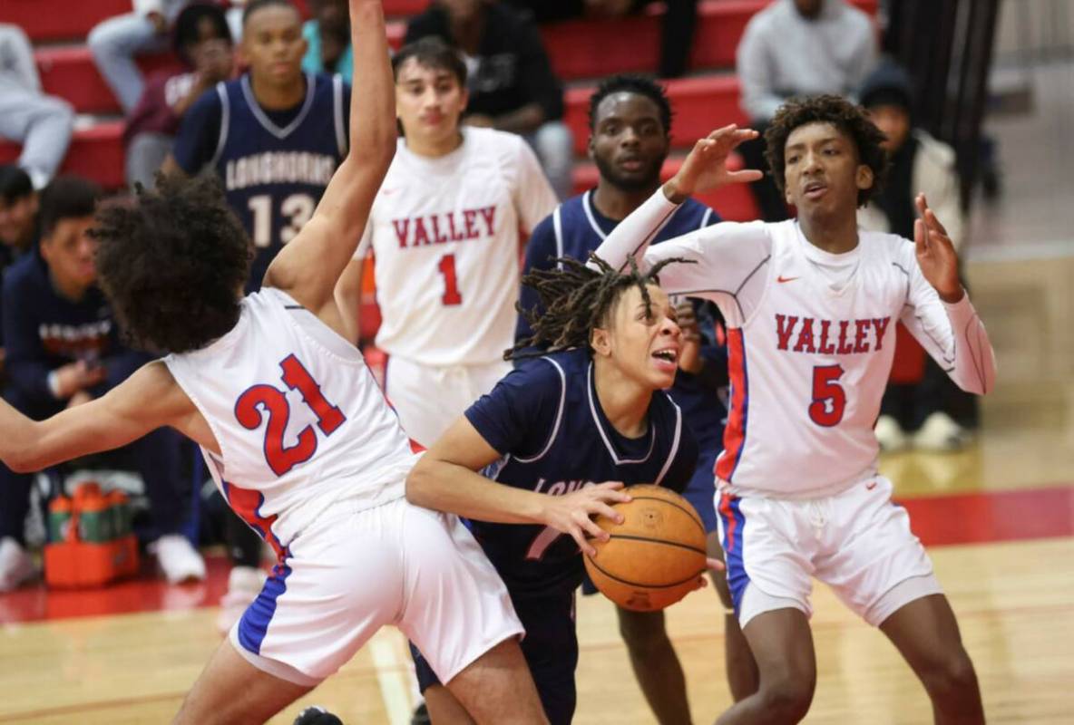 Legacy's guard Ja'Merion Brass (11) moves the ball between Valley's Kevan Wilkins (21) and Stev ...