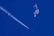 In this photo provided by Chad Fish, the remnants of a large balloon drift above the Atlantic O ...