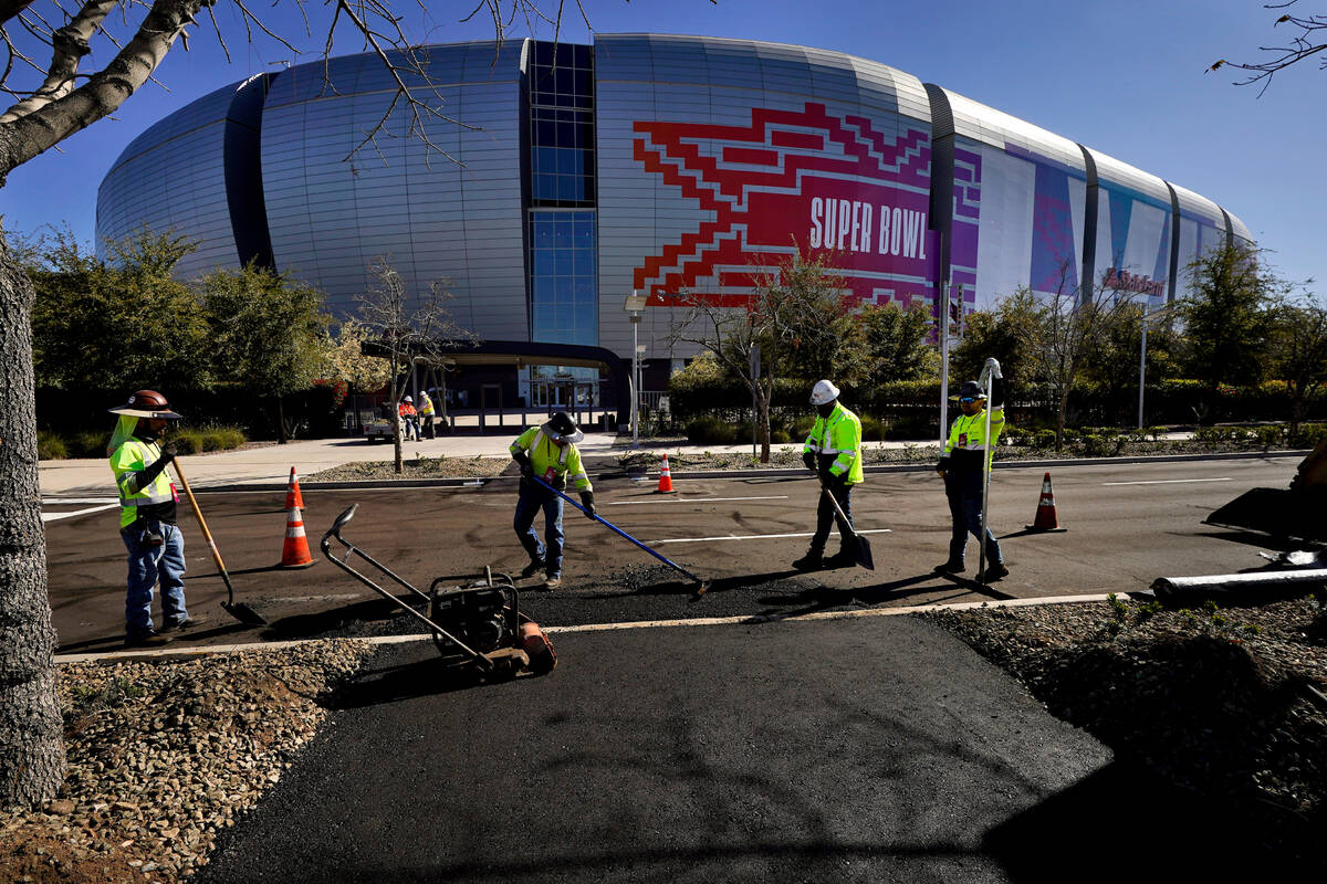 Workers prepare for the NFL Super Bowl LVII football game outside State Farm Stadium, Thursday, ...