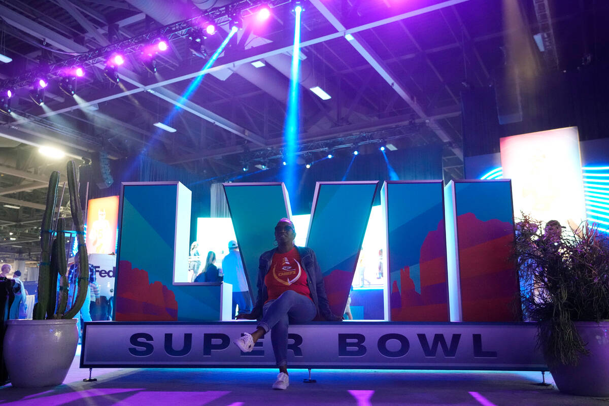 A Kanasas City Chiefs fan has her picture taken at the Super Bowl LVII logo at the Super Bowl E ...