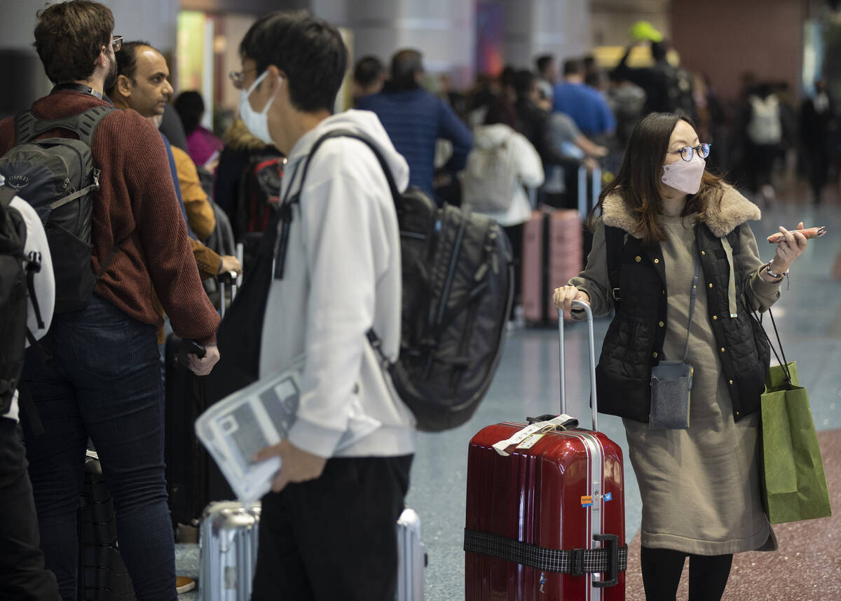 Travelers walk through terminal 1 at Harry Reid International Airport on Sunday, Nov. 27, 2022, ...