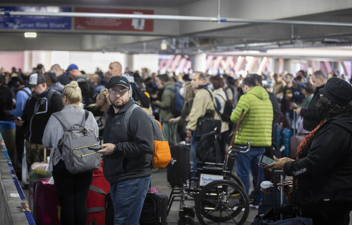 Travelers walk through terminal 1 at Harry Reid International Airport on Sunday, Nov. 27, 2022, ...