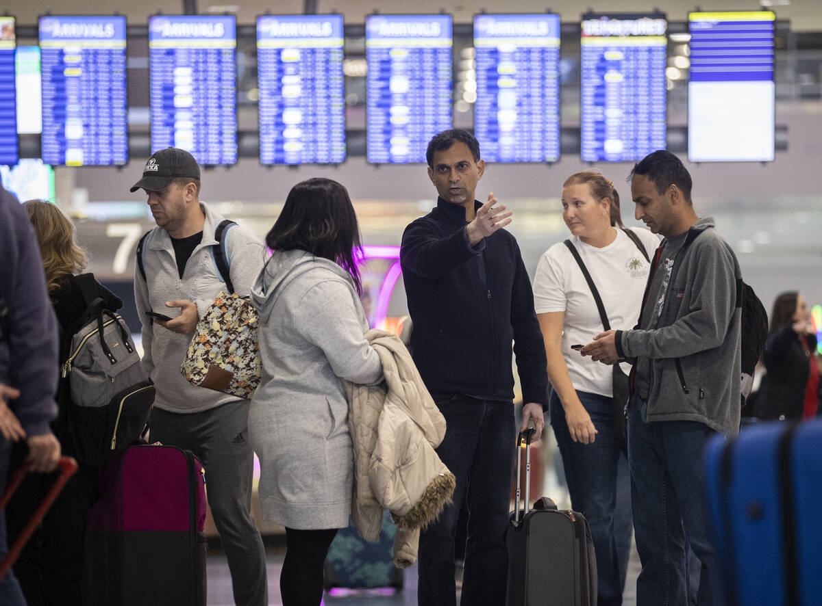 Travelers walk through terminal 1 at Harry Reid International Airport on Sunday, Nov. 27, 2022, ...