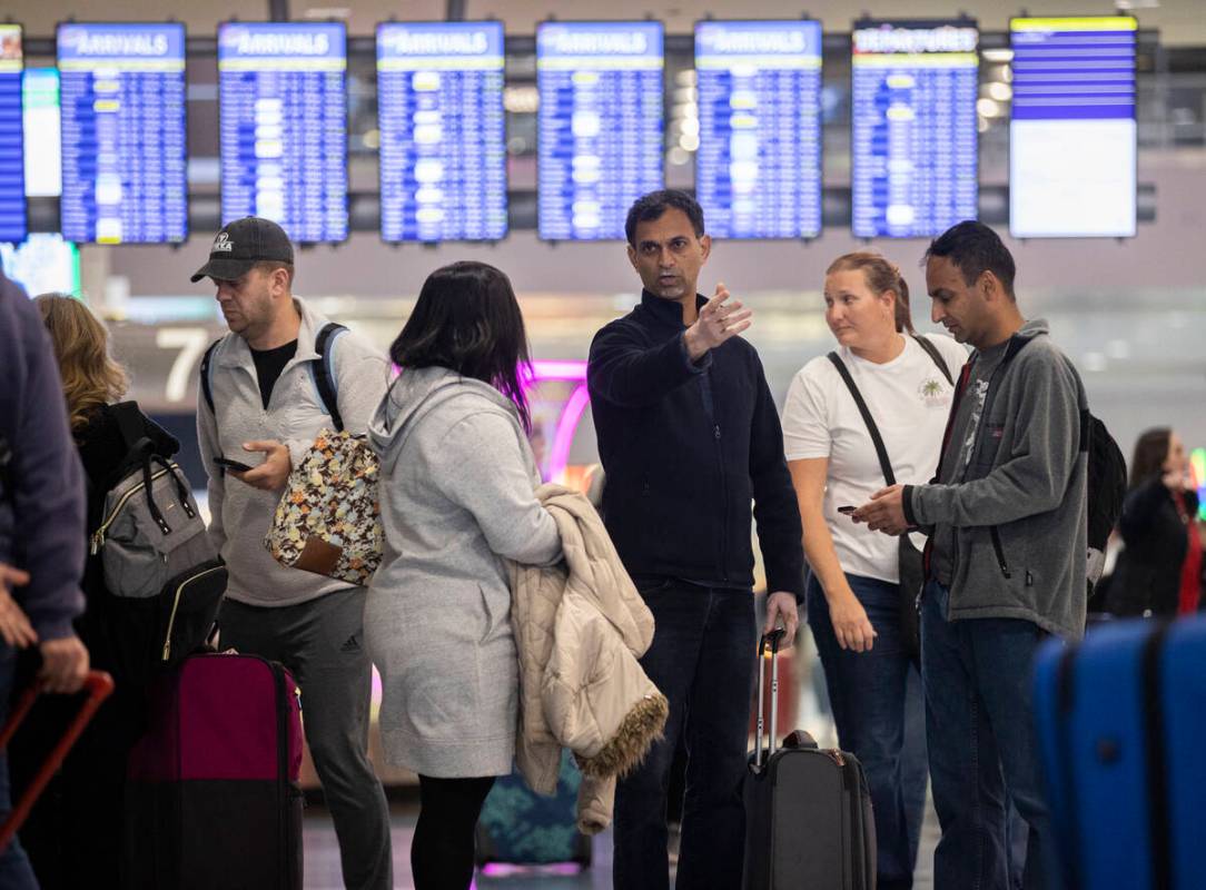 Travelers walk through terminal 1 at Harry Reid International Airport on Sunday, Nov. 27, 2022, ...