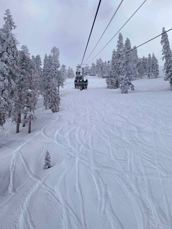 Tracks in the snow left behind by skiers beneath a quad chairlift at Diamond Peak Ski Resort in ...