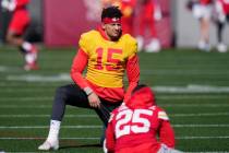 Kansas City Chiefs quarterback Patrick Mahomes (15) stretches with teammates, including running ...