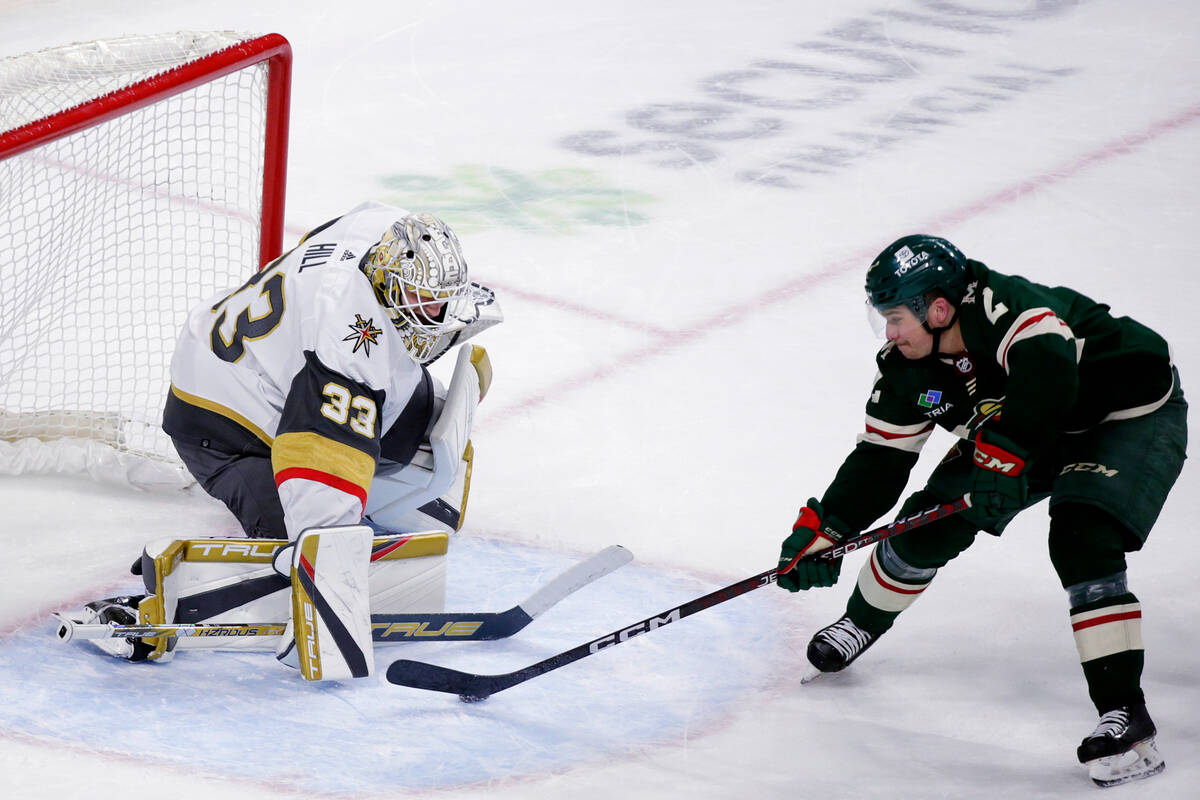 Vegas Golden Knights goaltender Adin Hill (33) blocks a shot by Minnesota Wild defenseman Calen ...