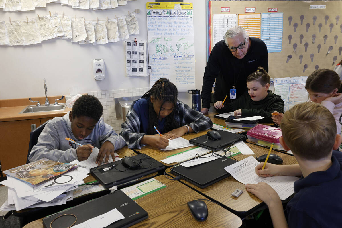 Ray Finucan, special education teaching assistant, helps children during a fifth grade class at ...