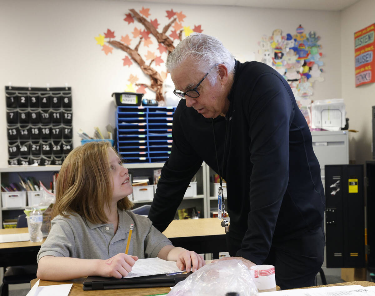 Ray Finucan, special education teaching assistant, talks with Bailey Tomola, 11, during a fifth ...