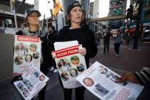 Jennifer Best of Las Vegas, center, and her sister Michele Mullins of Chicago hand out missing ...