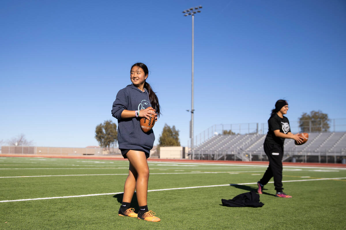 Akemi Higa, left, and Yalayna Medina, get ready to throw a ball during a flag football practice ...