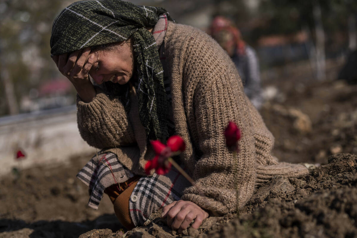 A member of the Vehibe family mourns a relative during the burial of one of the earthquake vict ...