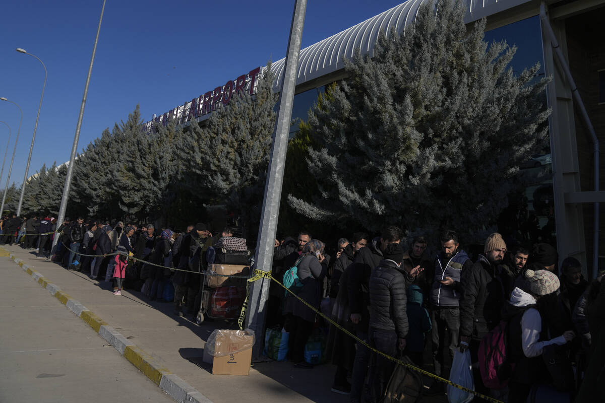 People line up outside Adiyaman domestic airport to leave the city, southern Turkey, Sunday, Fe ...