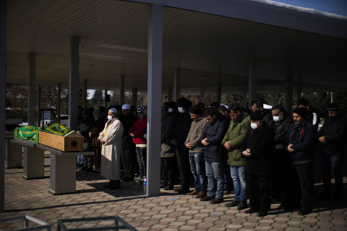 Men pray during the funeral of two people killed during the earthquake at Sehir cemetery in Mal ...