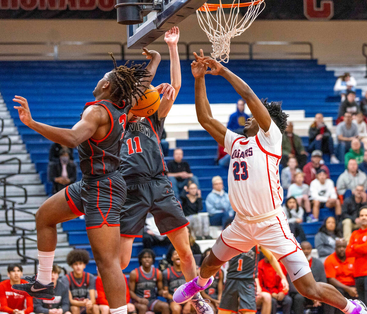 Coronado's Josiah Cunningham (23) has the ball slapped away by Arbor View's Brian Townsend (3) ...