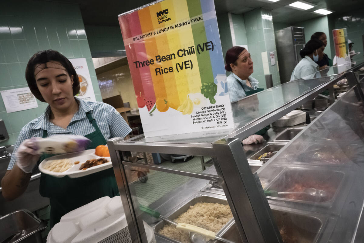 Cafeteria staff serve vegetarian and vegan options which include three-bean chili and rice to s ...