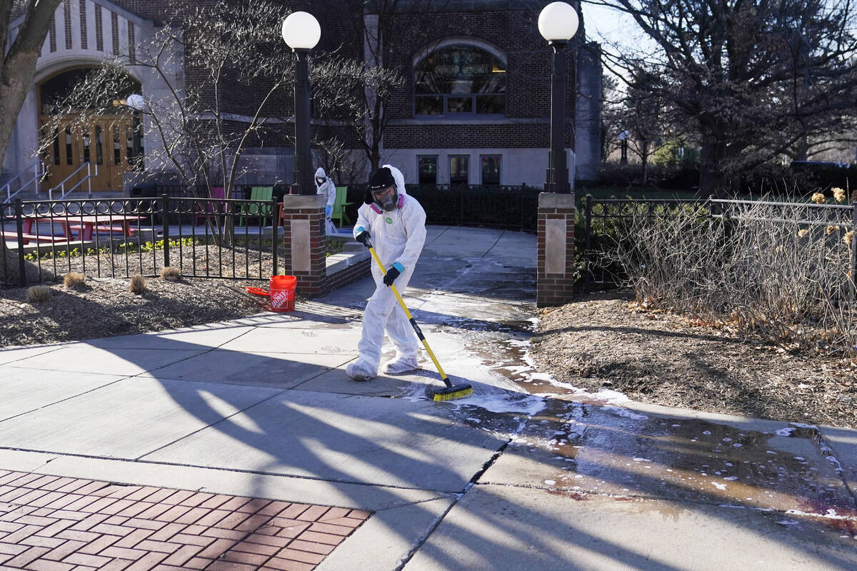 Workers clean up outside Berkey Hall at Michigan State University, Tuesday, Feb. 14, 2023, in E ...