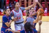 UNLV Lady Rebels guard Kenadee Winfrey (2) drives past Fresno State Bulldogs guard Keely Brown ...