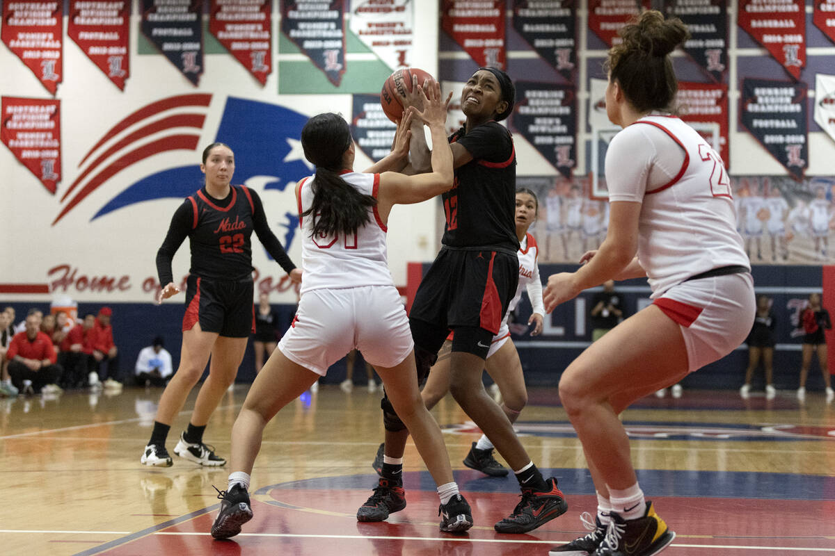 Coronado’s Jaila Childress (12) shoots against Liberty’s Faith Esquer (31) durin ...