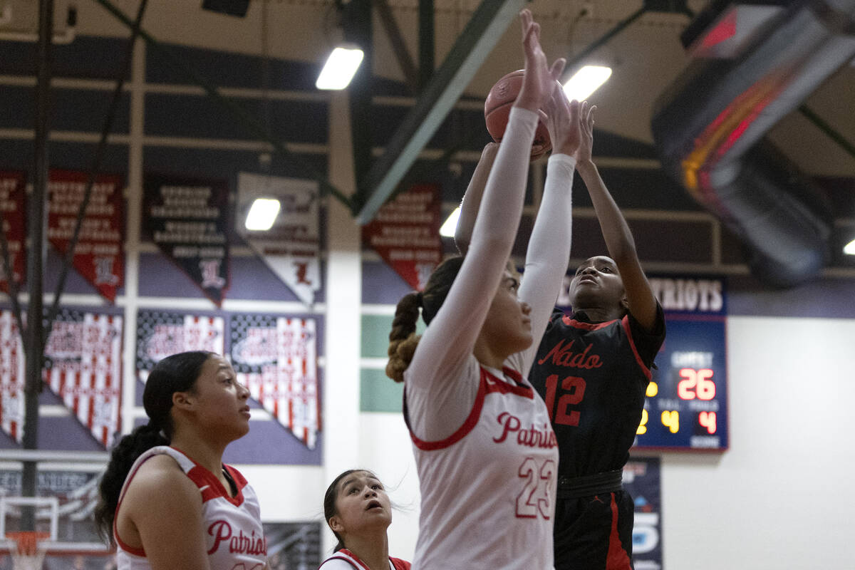 Coronado’s Jaila Childress (12) shoots against Liberty’s Adrienne Puletasi (23) d ...