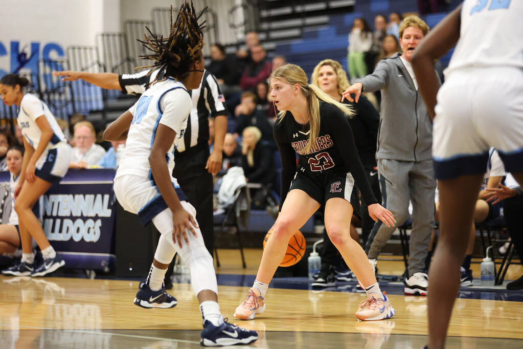 Faith Lutheran's Raina Forgue (23) looks for an open pass under pressure from Centennial's Kani ...