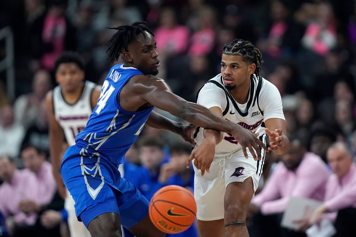 Creighton forward Arthur Kaluma, left, defends as Providence forward Bryce Hopkins, right, pass ...