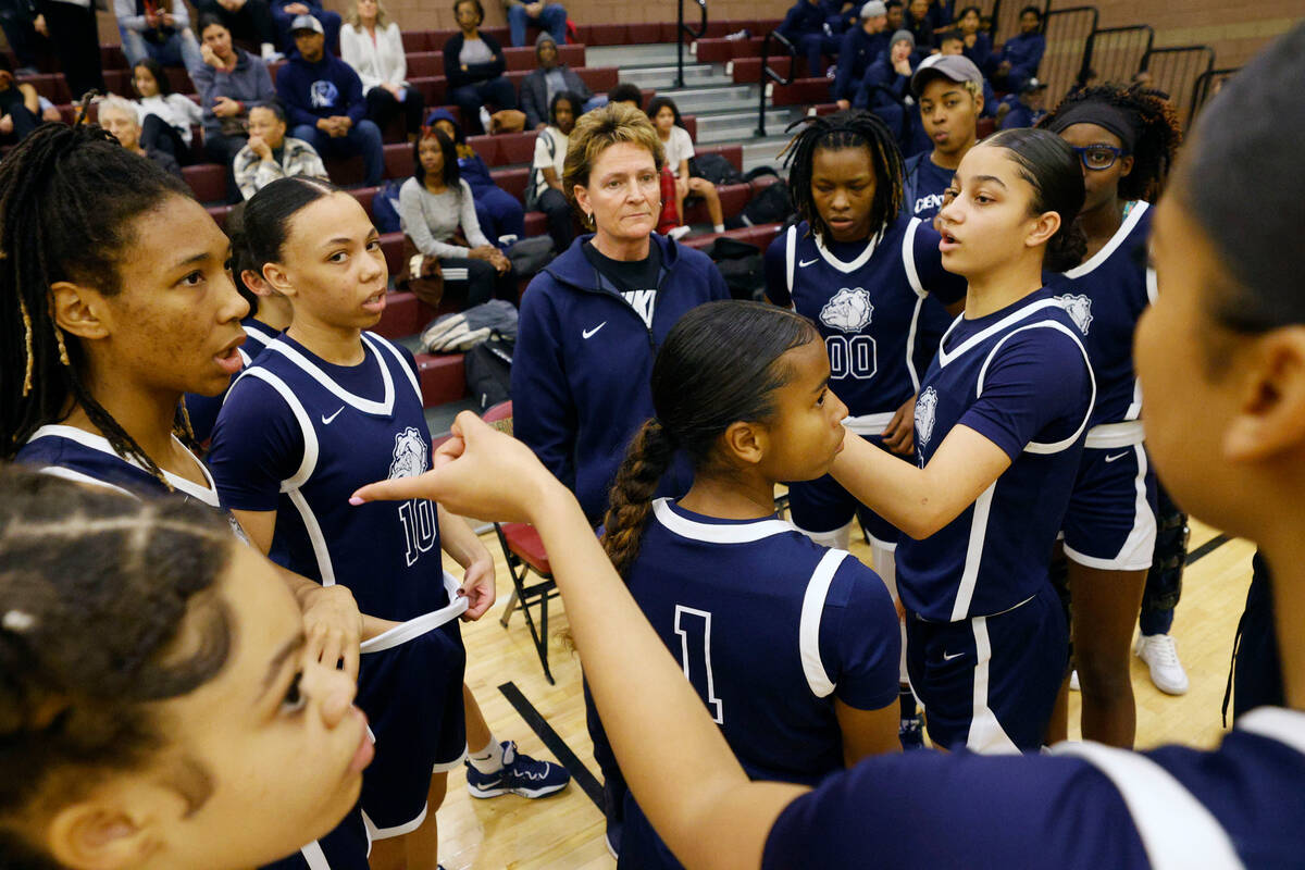 Centennial's head coach Karen Weitz, center, listens to her players before a basketball game ag ...