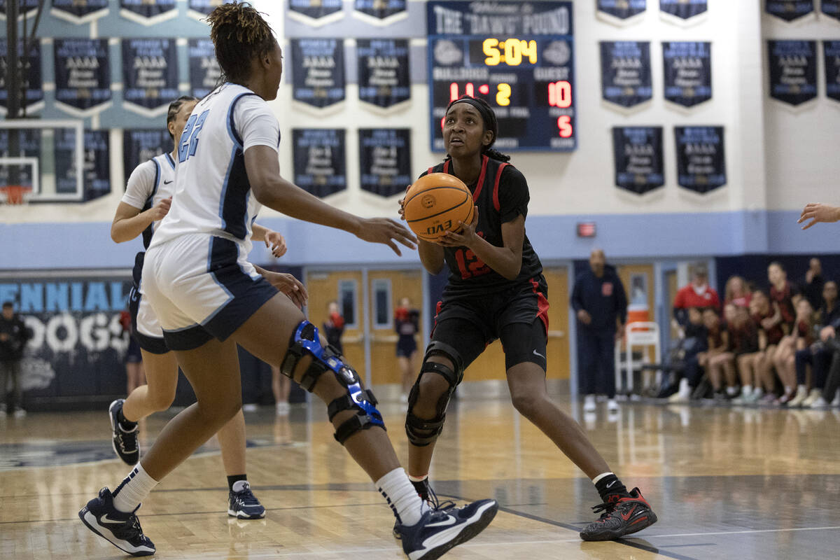 Coronado’s Jaila Childress (12) shoots against Centennial’s Kaliyah Dillard (22) ...