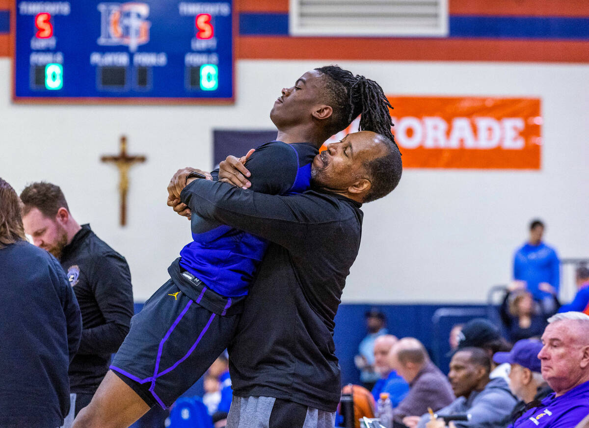 Durango assistant coach Mike Lee helps to stretch out guard Tylen Riley (10) before the first h ...