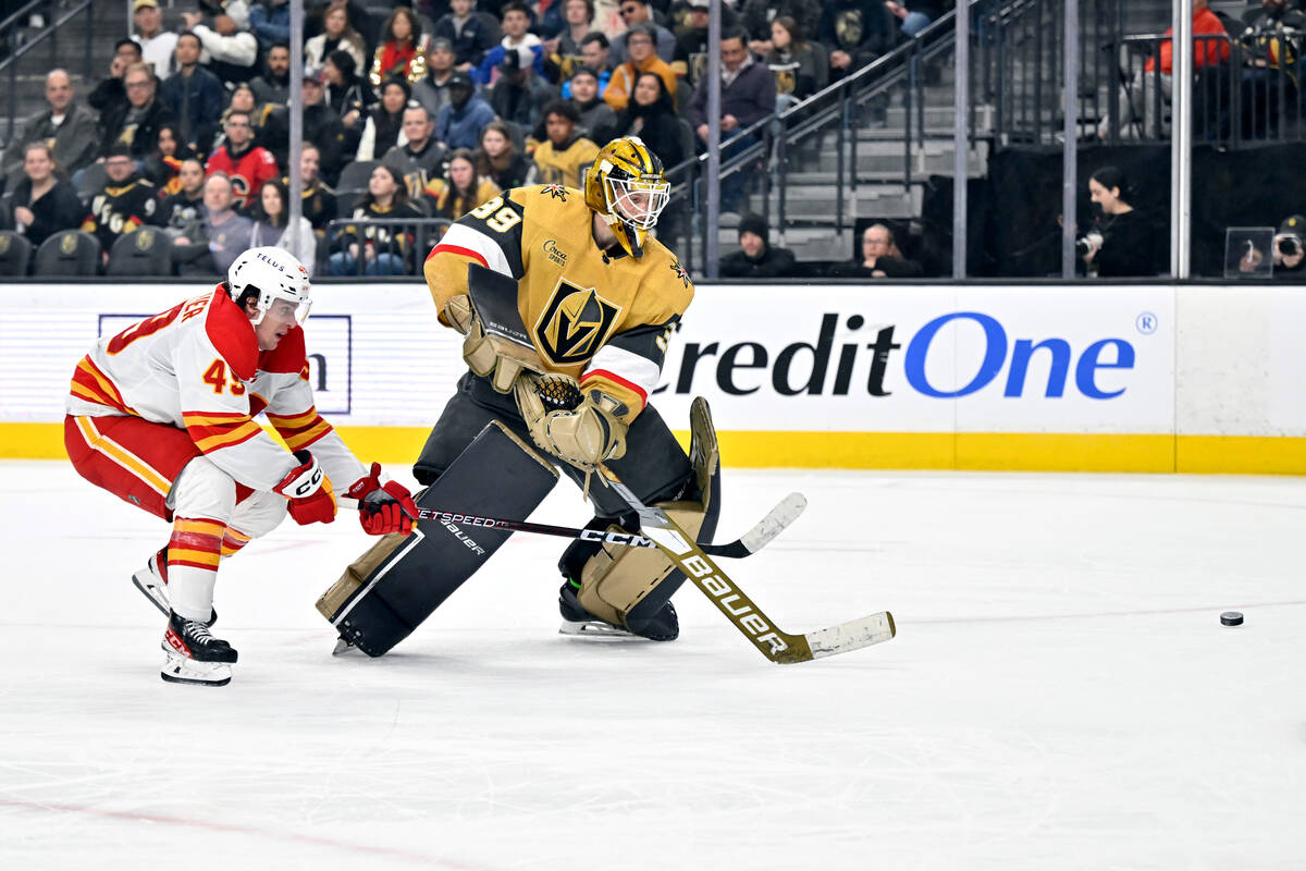 Calgary Flames left wing Jakob Pelletier (49) and Vegas Golden Knights goaltender Laurent Bross ...